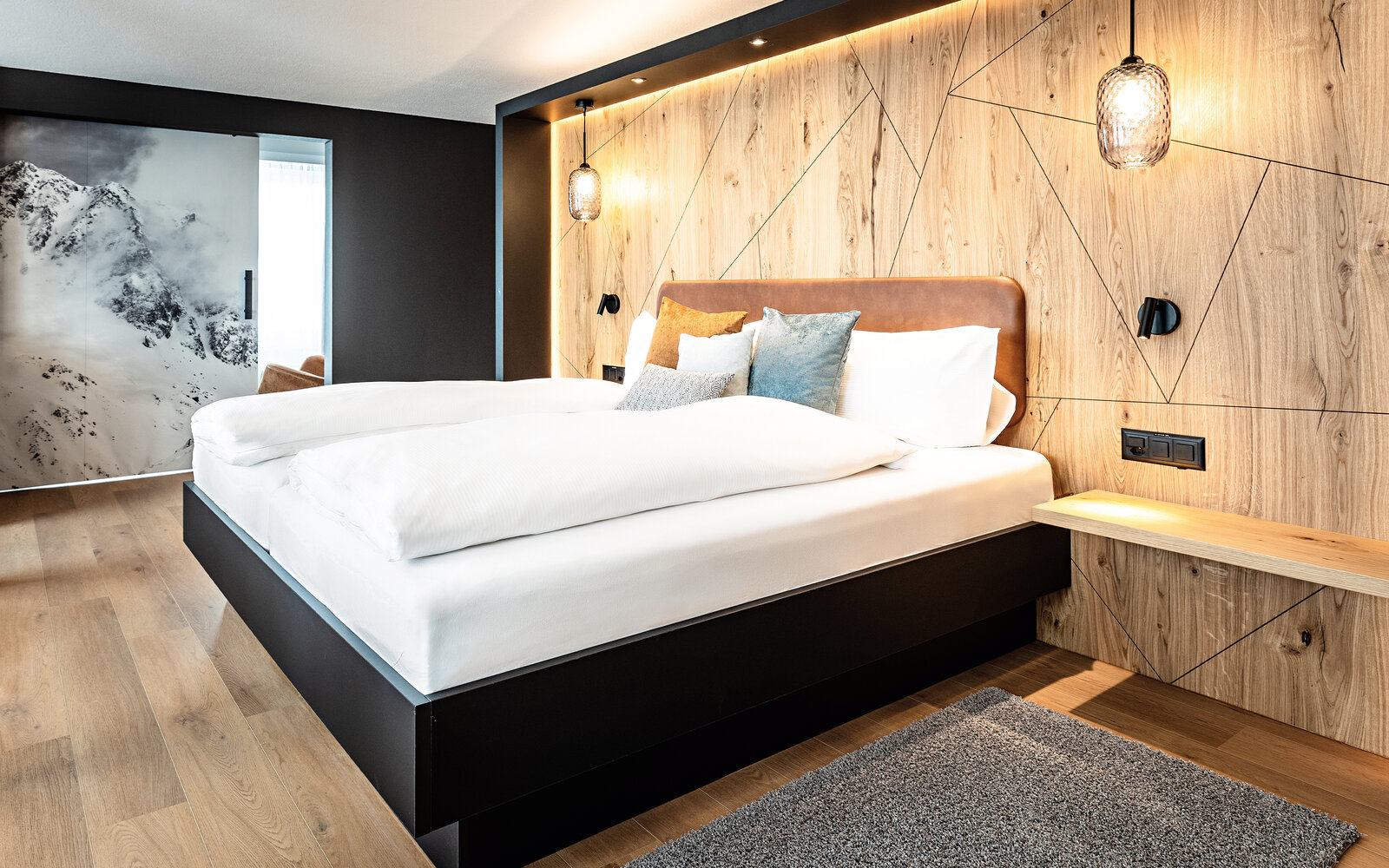 Zieflekoch hotel piz badus Andermatt Schweiz zimmer suite doppelzimmer doppelbett eiche wandbild berge Hängeleuchten winter