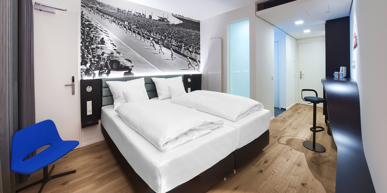 zieflekoch Hotel V8 Motorworld Doppelbett Bett Doppelzimmer Zimmer Autos Rennwagen Schreibtisch Schwarz Weiß Holz
