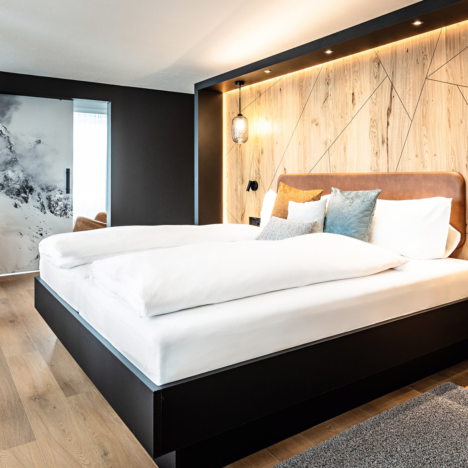 Zieflekoch hotel piz badus Andermatt Schweiz zimmer suite doppelzimmer doppelbett eiche wandbild berge Hängeleuchten winter