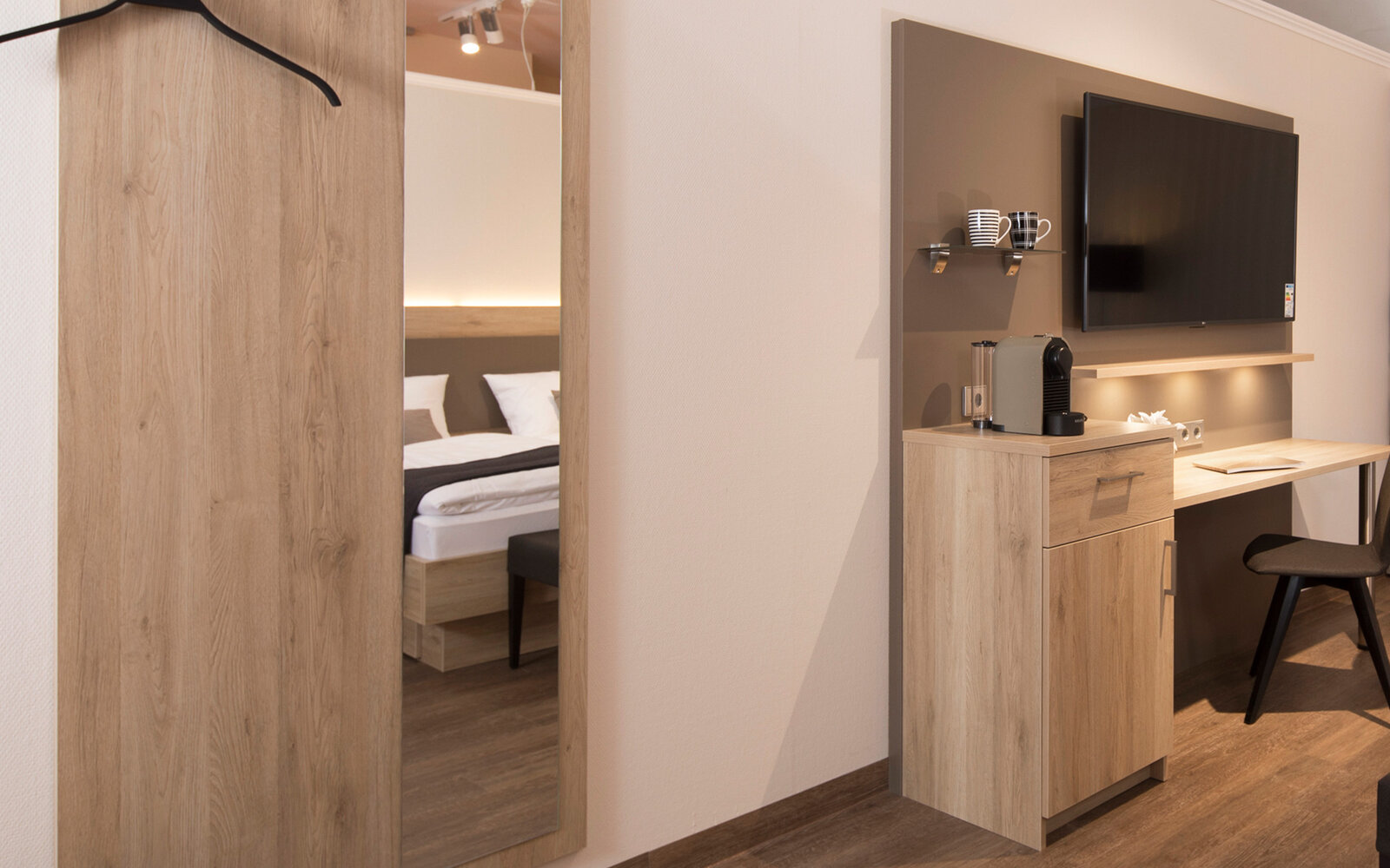 zieflekoch musterzimmer zaris doppelbett bett holz kissen lampen indirekte beleuchtung schreibtisch tv ablage sessel stuhl polsterbank spiegel garderobe