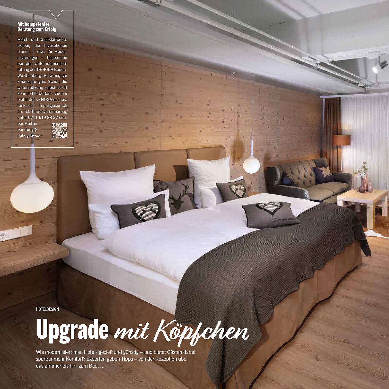 Gemütliches Hotelzimmer aus Holz mit modernem Design. Ein großes Bett mit weißen Kissen, dekoriert mit Herzmotiven, steht im Vordergrund. Rechts im Bild ein Sofa und Tischlampen. Die Atmosphäre ist warm und einladend, ideal für Entspannung und Komfort.