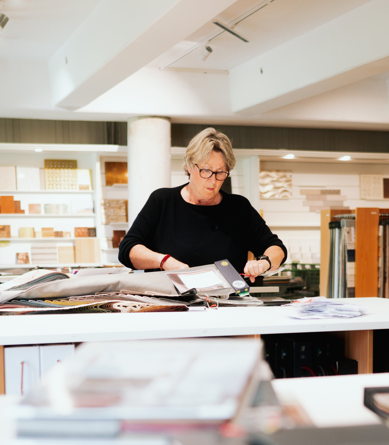 Sortieren von Stoffmustern durch Frau Ziefle im Showroom von ziflekoch