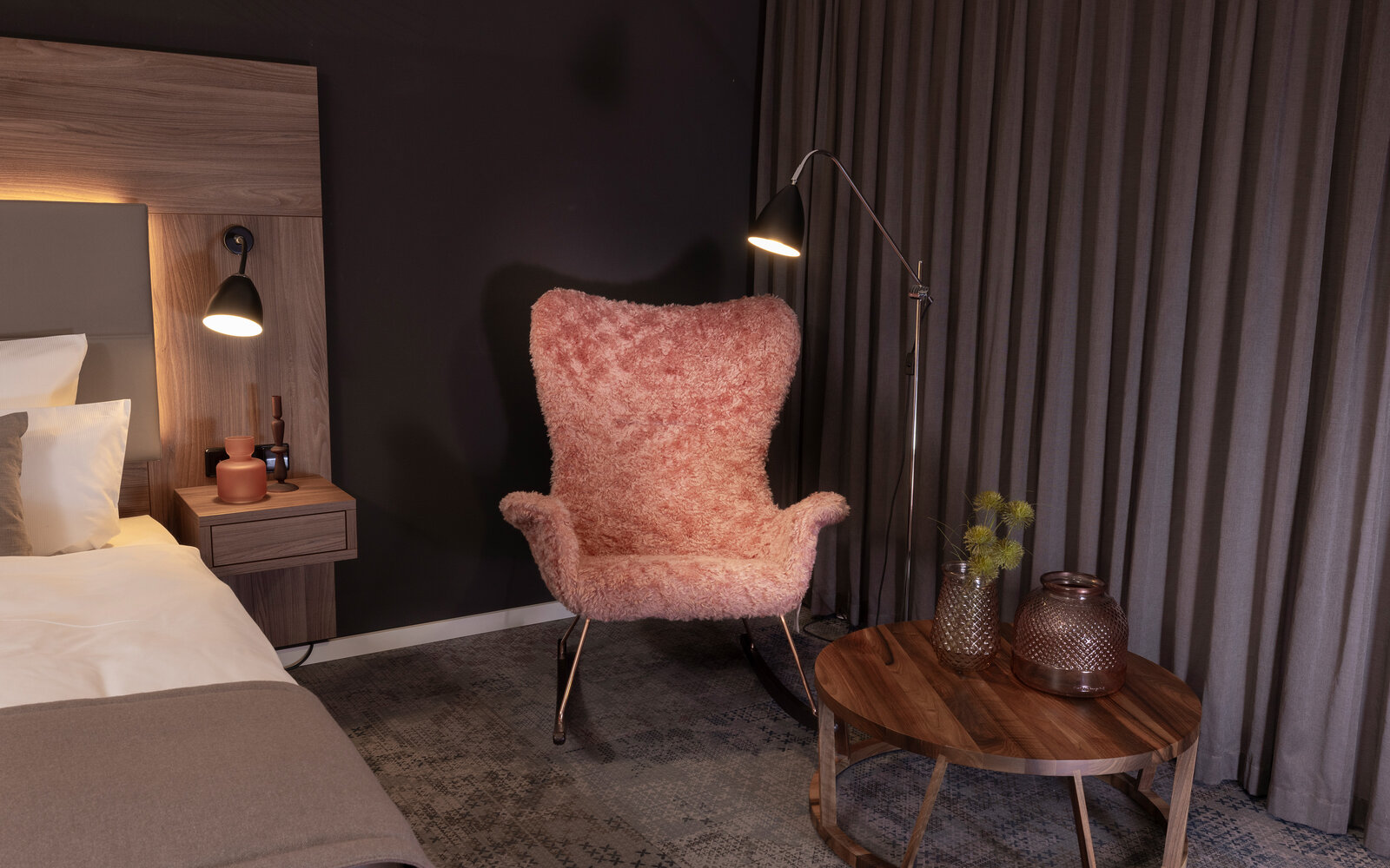 pinker flauschiger Sessel in dunklem soft beleuchtetem Hotelzimmer