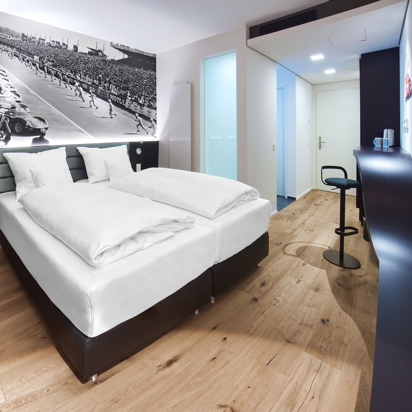 zieflekoch Hotel V8 Motorworld Doppelbett Bett Doppelzimmer Zimmer Autos Rennwagen Schreibtisch Schwarz Weiß Holz