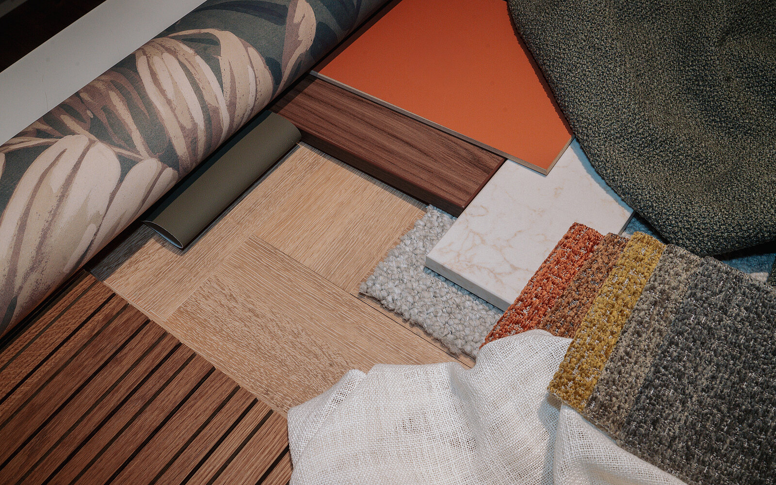 Eine Anordnung verschiedener Materialien und Oberflächen für Innenräume. Dazu gehören Tapeten, Holz- und Fliesenmuster sowie verschiedene Textilien in unterschiedlichen Farben. Die Auswahl zeigt eine Mischung aus natürlichen und modernen Designs, die für die Raumgestaltung verwendet werden können.