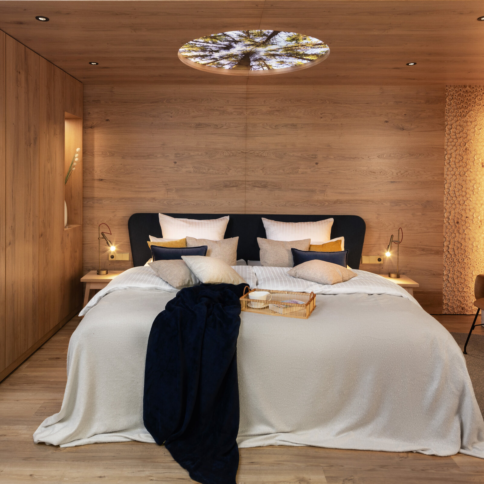 Frontale Ansicht auf das Bett mit Deckenbeleuchtung im Musterzimmer Harmonie
