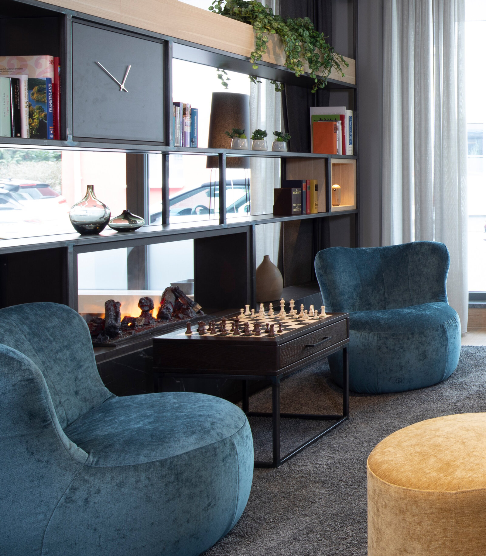 Aparthotel Hotel Zeitwohnhaus Zieflekoch Erlangen Lounge Sessel Samt blau gelb Regalwand dunkles Holz Schachspiel Teppich