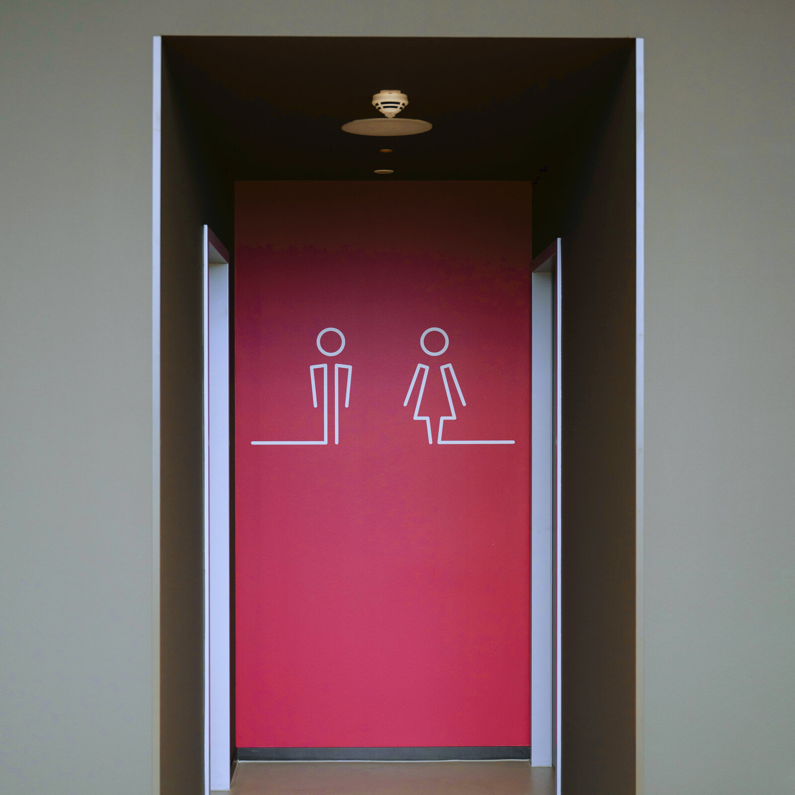 pinke wand mit weißer geschelechterkennung für Toiletten