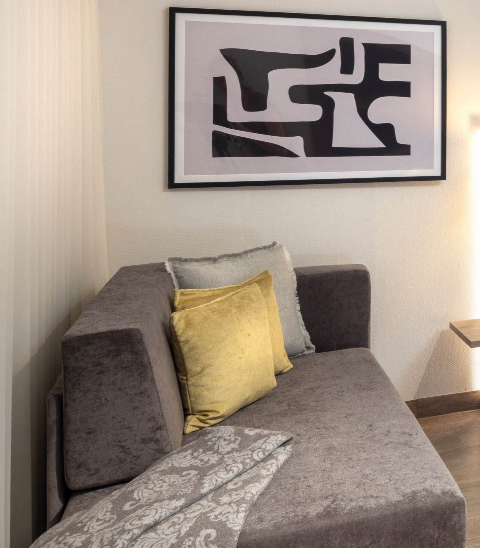zieflekoch musterzimmer zaris, modernes Zimmer mit einem grauen Sofa, abstrakter Wandkunst