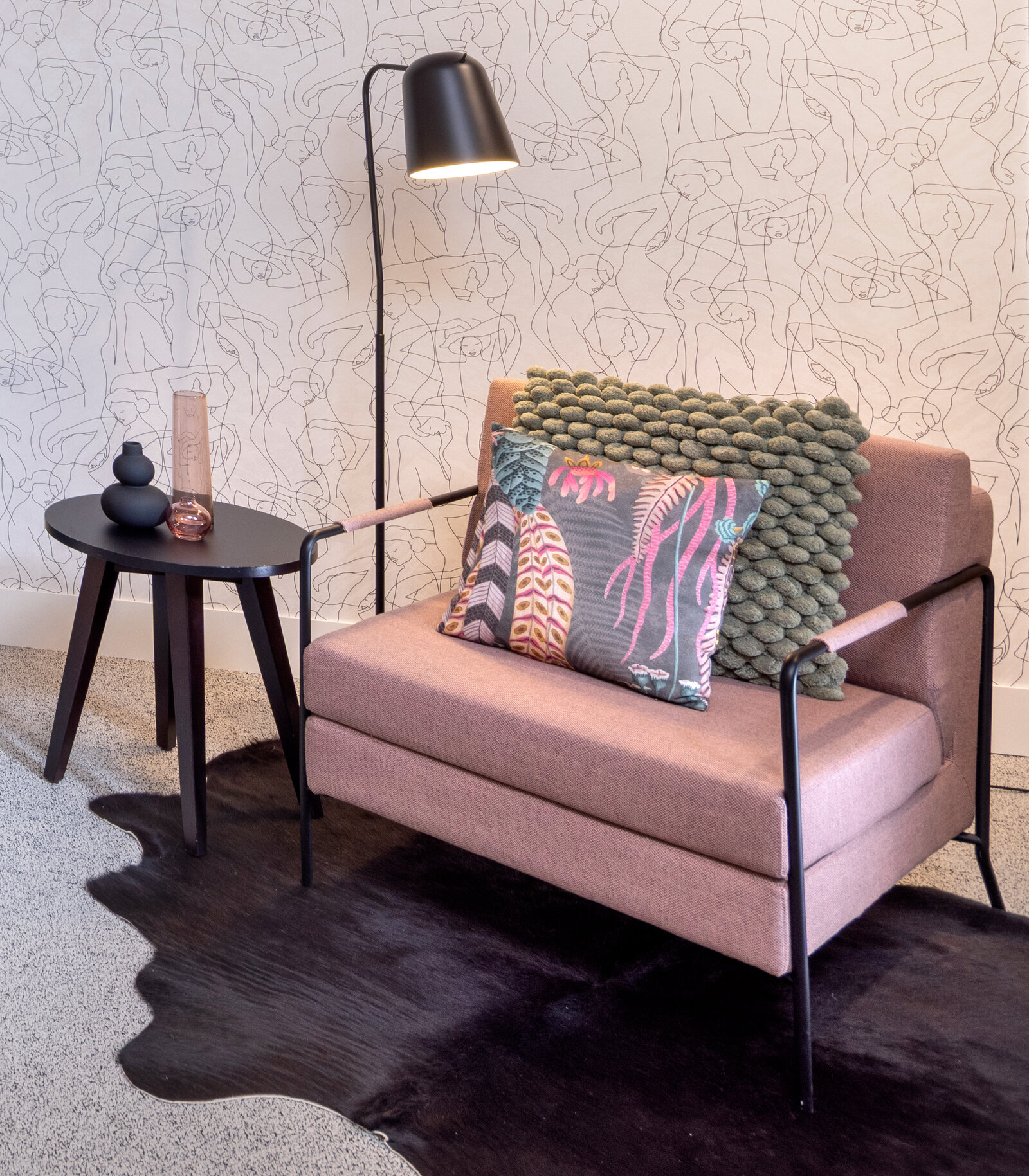 zieflekoch musterzimmer zenit, modernes Zimmer mit einem rosafarbenen Sessel und einer abstrakten Motivtapete, der Teppichboden und ein dunkler Teppich verleihen dem Raum Wärme