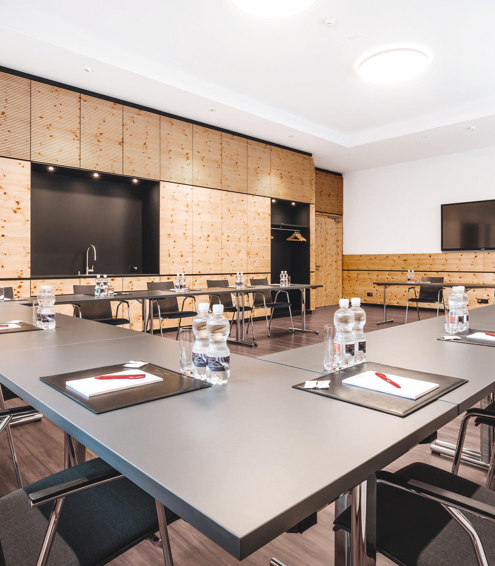 zieflekoch Laudinella Konferenzraum Seminarraum Tische Stühle Schrankwand Bildschirme Holzschrank Holzwand Holz