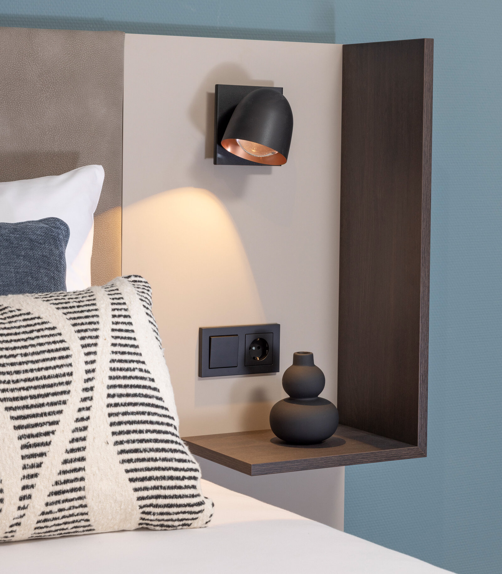Nachtkästchenmodul für Hotelbett vor türkieser Wand