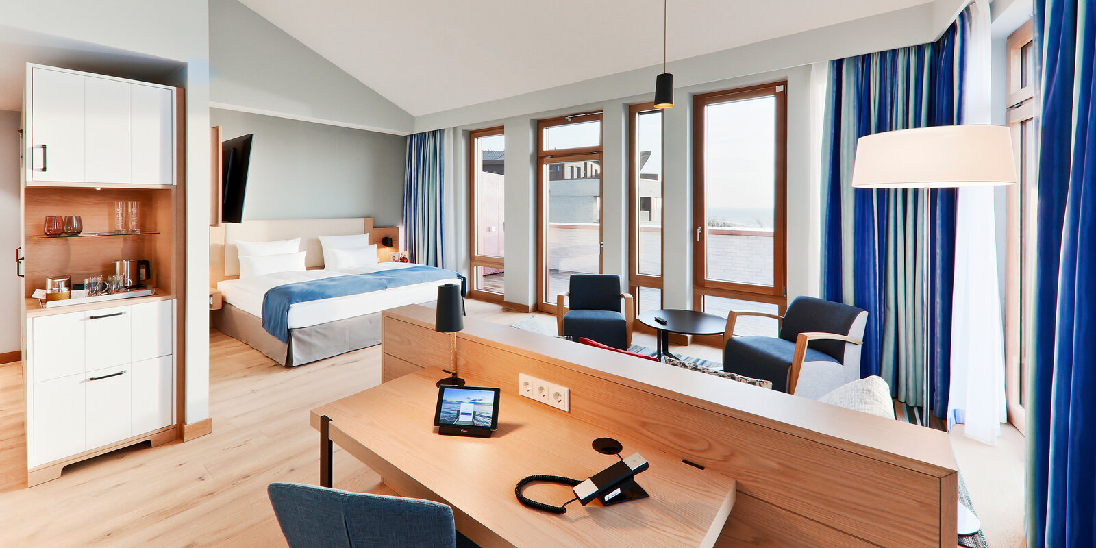 zieflekoch Wellnessresort Upstalsboom Wyk auf Föhr Zimmer Apartment Doppelbett Schlafzimmer Wohnzimmer Sessel Holz