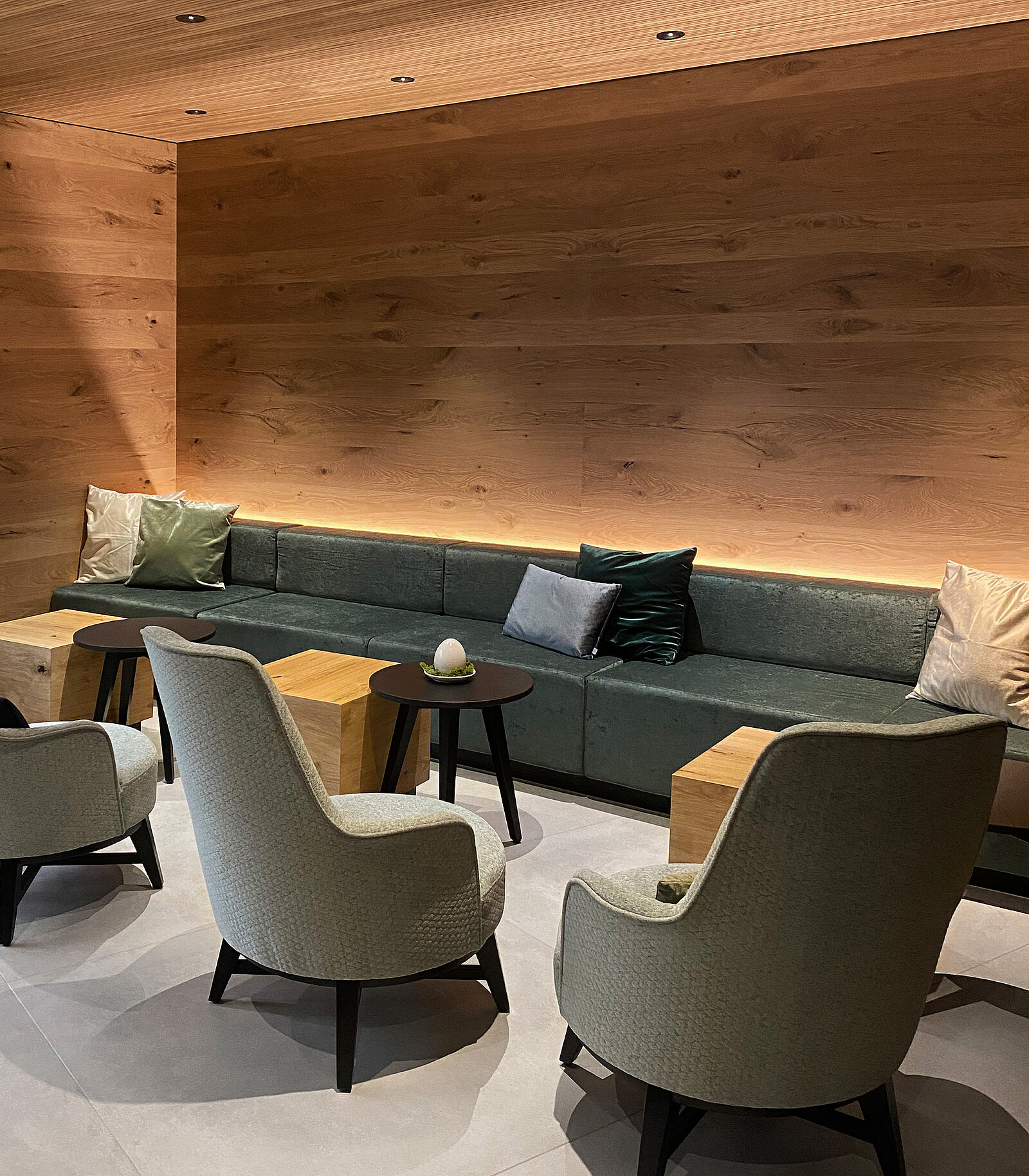 zieflekoch wirthshof resort hotel holz lounge salon lobby sessel couch sofa sitzbank sitzecke kissen hocker beistelltisch indirekte beleuchtung