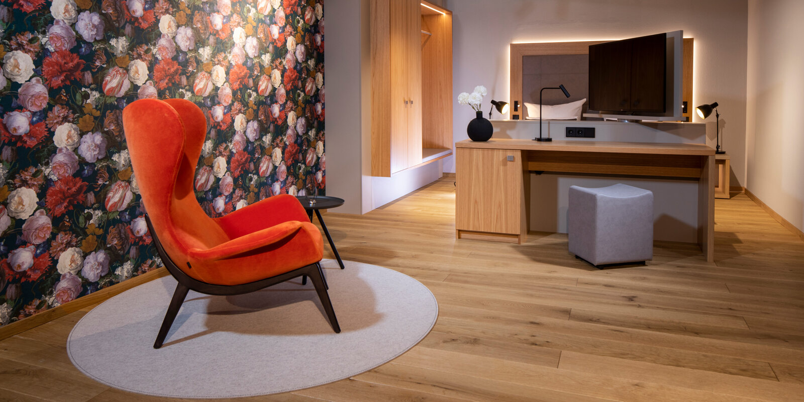 zieflekoch musterzimmer ziloft zimmer holz sessel bett doppelbett schrank einbauschrank tapete blumenmuster hocker schreibtisch schreibtischlampe beistelltisch nachttischlampe indirekte beleuchtung tv schwenkbar drehbar teppich