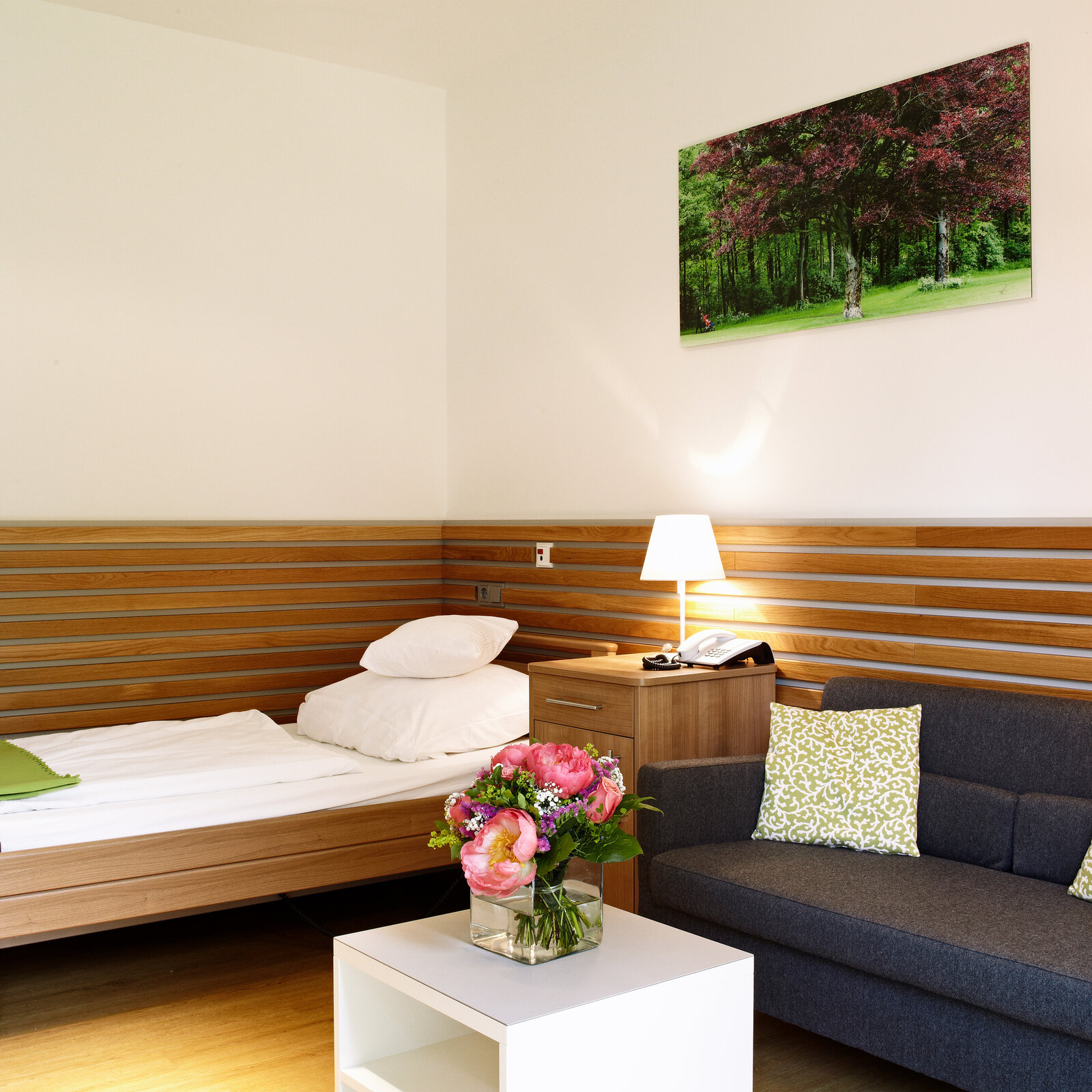 zieflekoch Fachklinik Klinik im Alpenpark Zimmer Patientenzimmer Holzwand Bett Holzbett Sofa Couch Holz