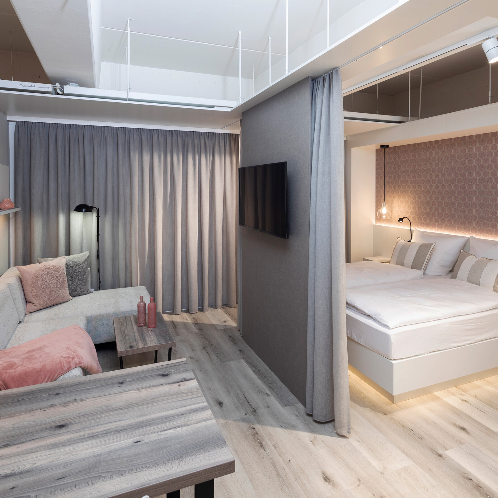 zieflekoch Musterzimmer Zwin Raumtrenner Vorhang Schlafzimmer Wohnzimmer Wohnbereich Couch Sofa Esstisch Bett Doppelbett Tapete Regal Holz Grau Rosa