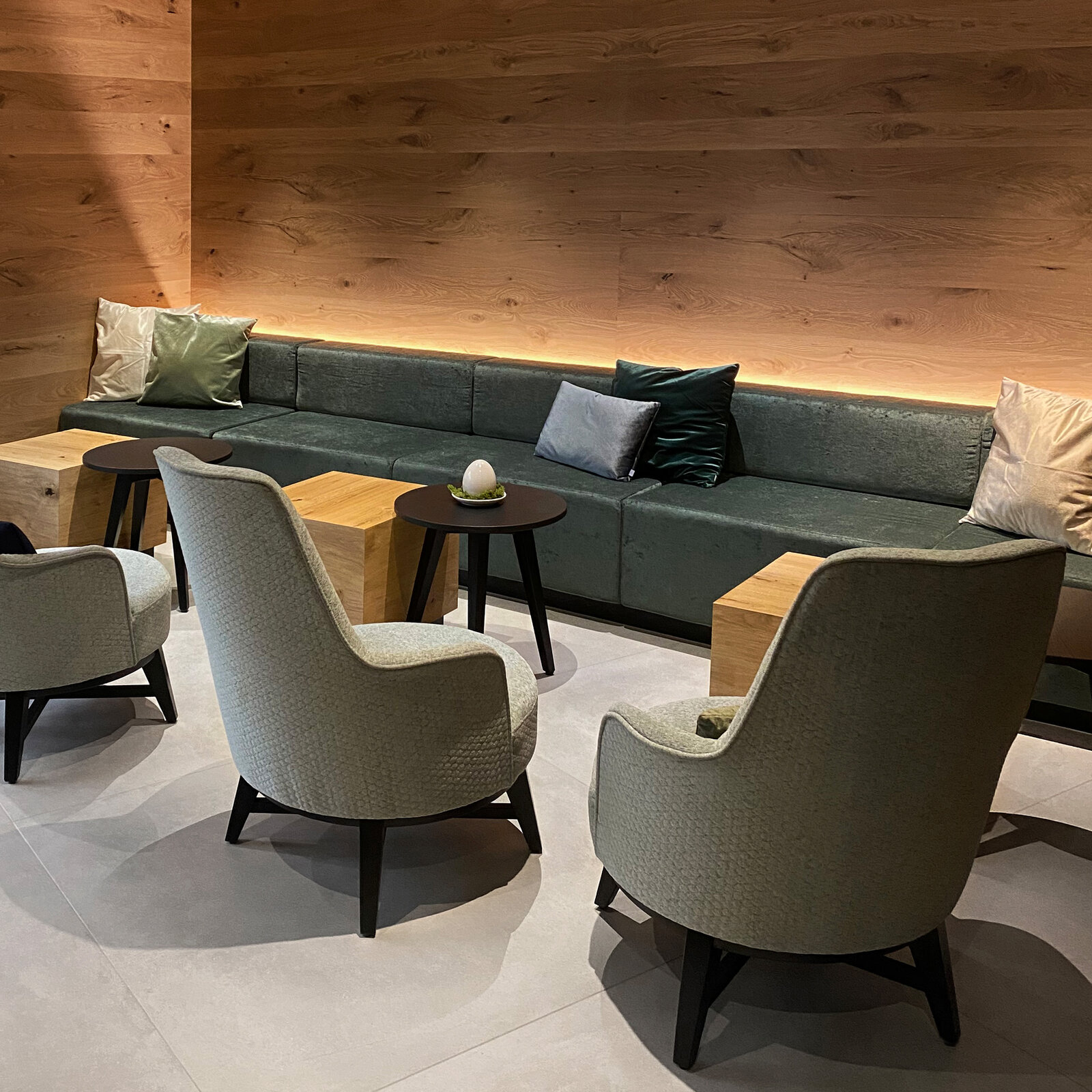 zieflekoch wirthshof resort hotel holz lounge salon lobby sessel couch sofa sitzbank sitzecke kissen hocker beistelltisch indirekte beleuchtung